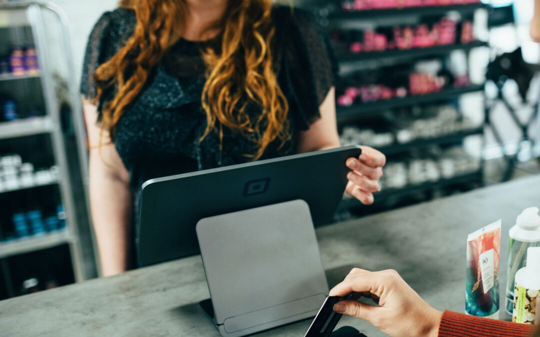 woman swiping credit card at store register